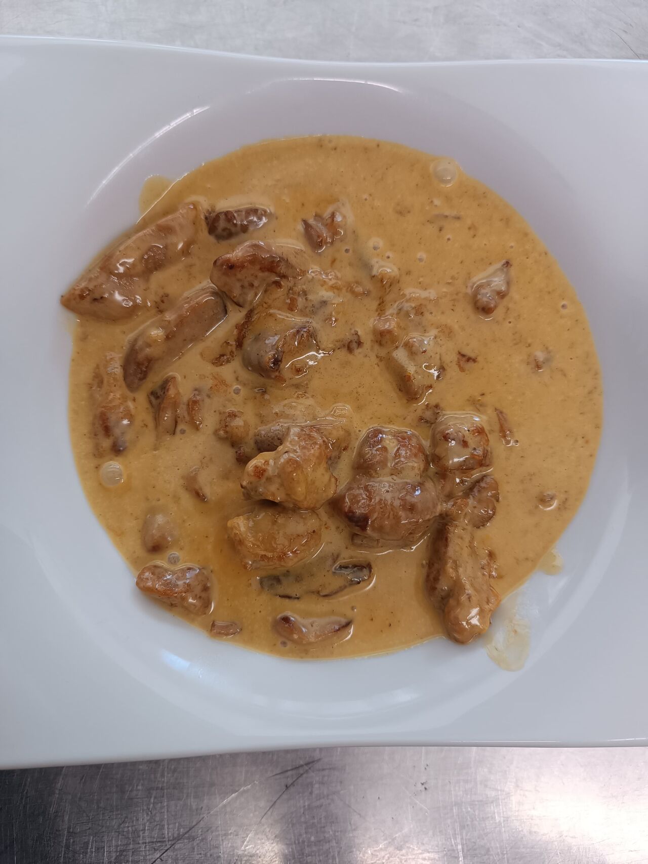 Salón con mesas preparadas y estanterías de vino